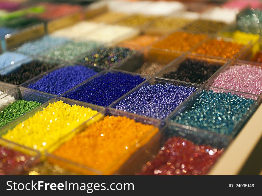 Multi-colored beads in a box on a shelf in the market. Multi-colored beads in a box on a shelf in the market