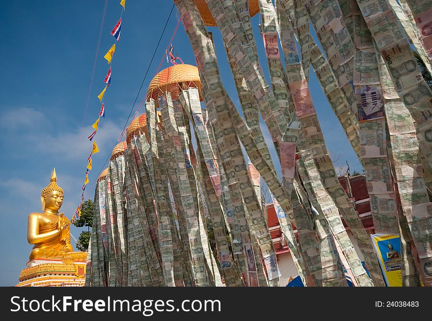 Beautiful exterior decoration in wat thai on holy day with line of flags and money lantern above the floor connecting to the big golden buddha image. Beautiful exterior decoration in wat thai on holy day with line of flags and money lantern above the floor connecting to the big golden buddha image.