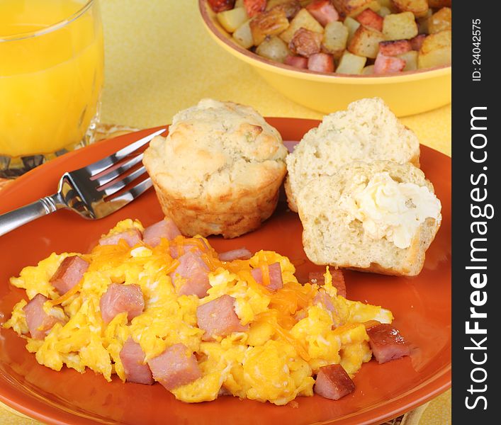 Scrambled eggs with ham, biscuits and orange juice breakfast. Scrambled eggs with ham, biscuits and orange juice breakfast