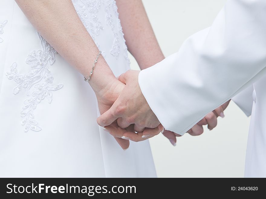 A bride and groom holding hands during the wedding ceremony