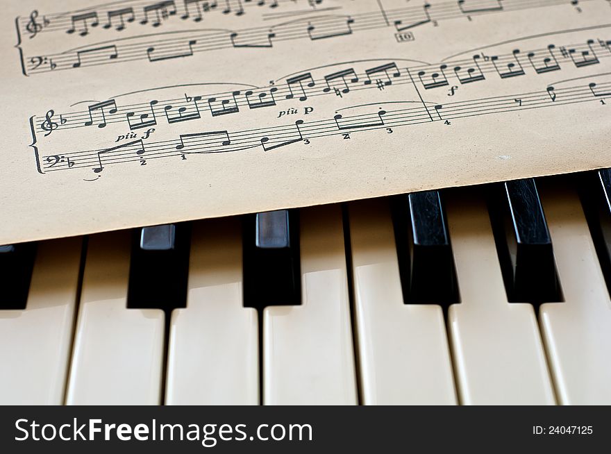 Piano keyboard with note sheets lying on it. Piano keyboard with note sheets lying on it