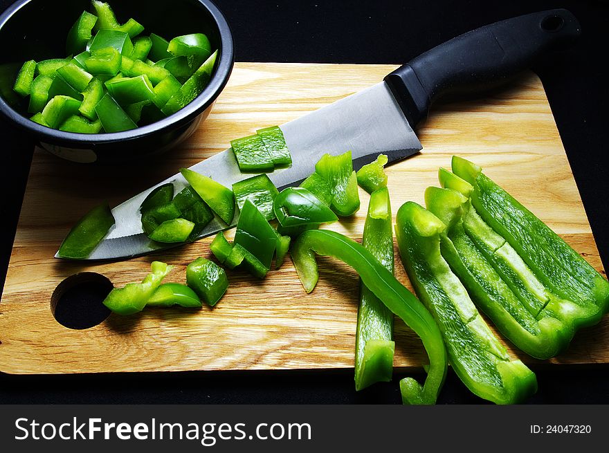 Sweet green peppers being diced in a bowl. Sweet green peppers being diced in a bowl