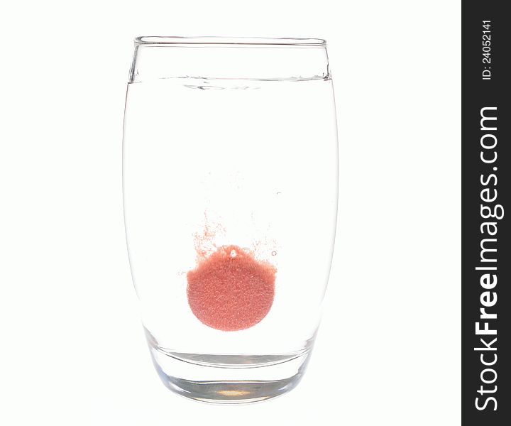 An effervescent tablet dissolving in a glass of water. An effervescent tablet dissolving in a glass of water