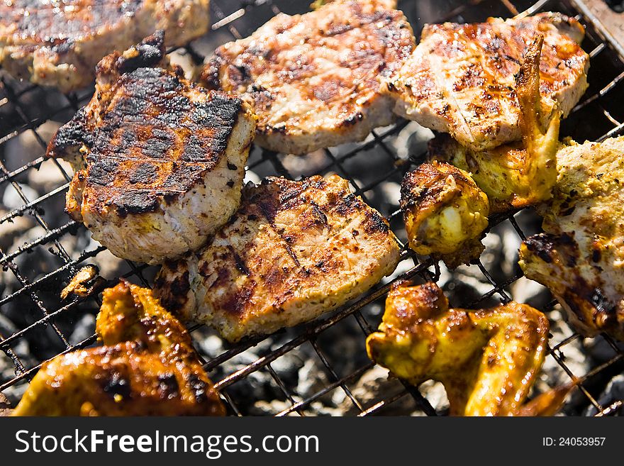 Chicken wings on the grill and pork