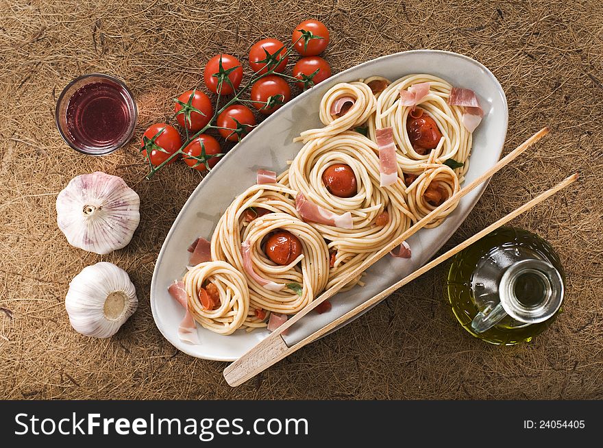 Fresh spaghetti with prosciutto and tomato sauce close up. Fresh spaghetti with prosciutto and tomato sauce close up