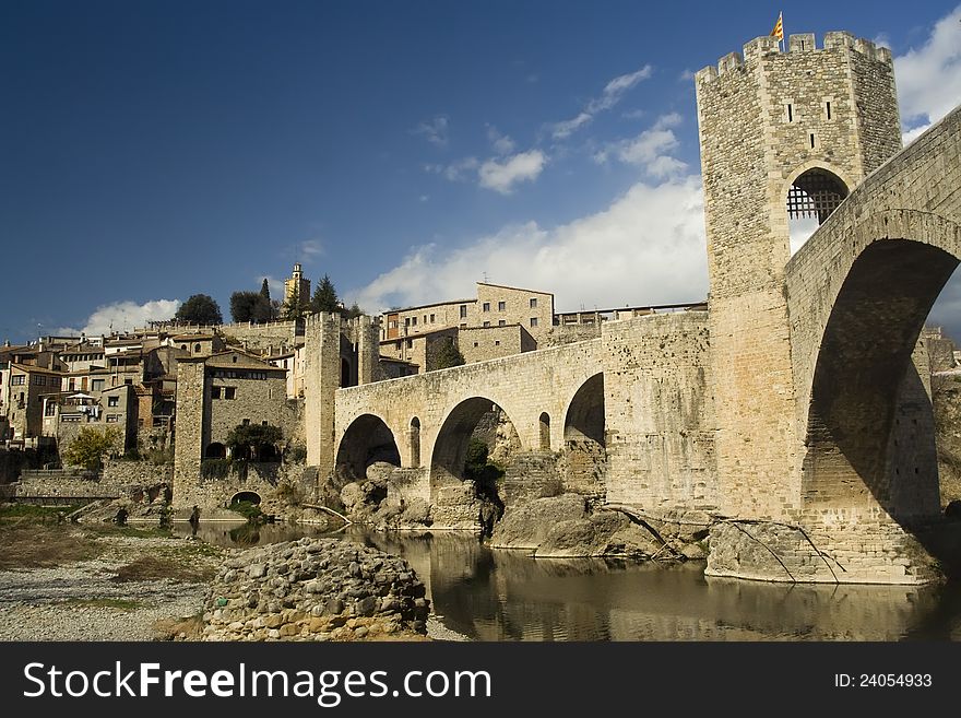 Cityscape of Besalu, Spain, at early spring. Roman bridge, now pedestrian, with Catalonia flag is at the front.