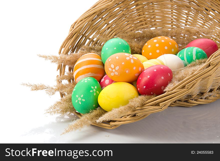 Basket with colorful Easter eggs on a white background