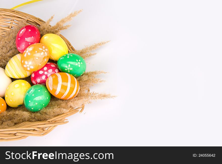Basket with colorful Easter eggs on a grey background