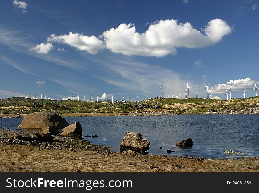 Landscape with lake, clouds and aerogenerators in background