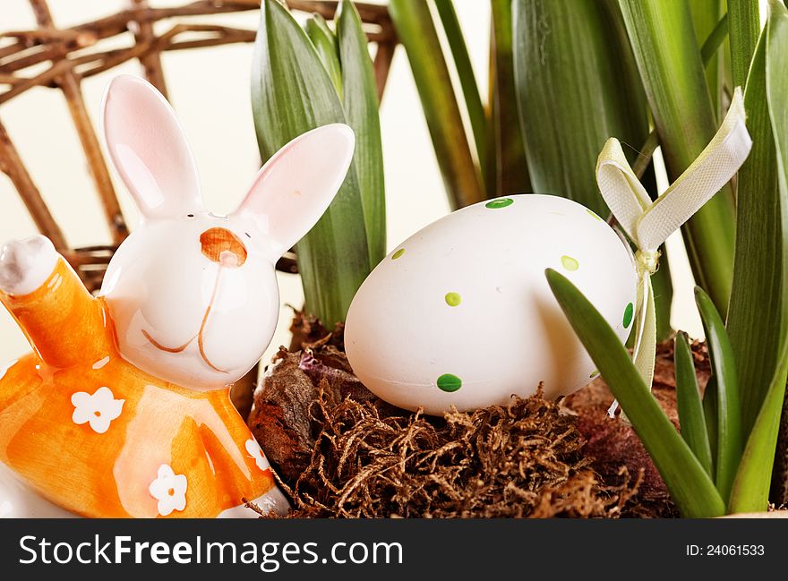 Colorful easter egg on old nest and rabbit decoration