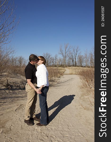 A mature couple in love on the beach during springtime. A mature couple in love on the beach during springtime.