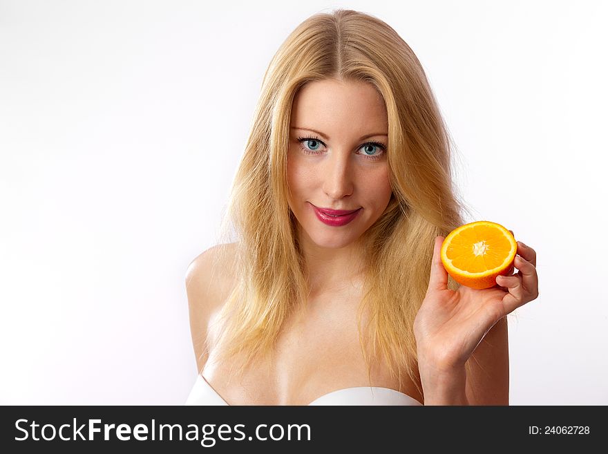Closeup of young, blond, fit, beautiful caucasian woman with white bra holding half orange. Closeup of young, blond, fit, beautiful caucasian woman with white bra holding half orange