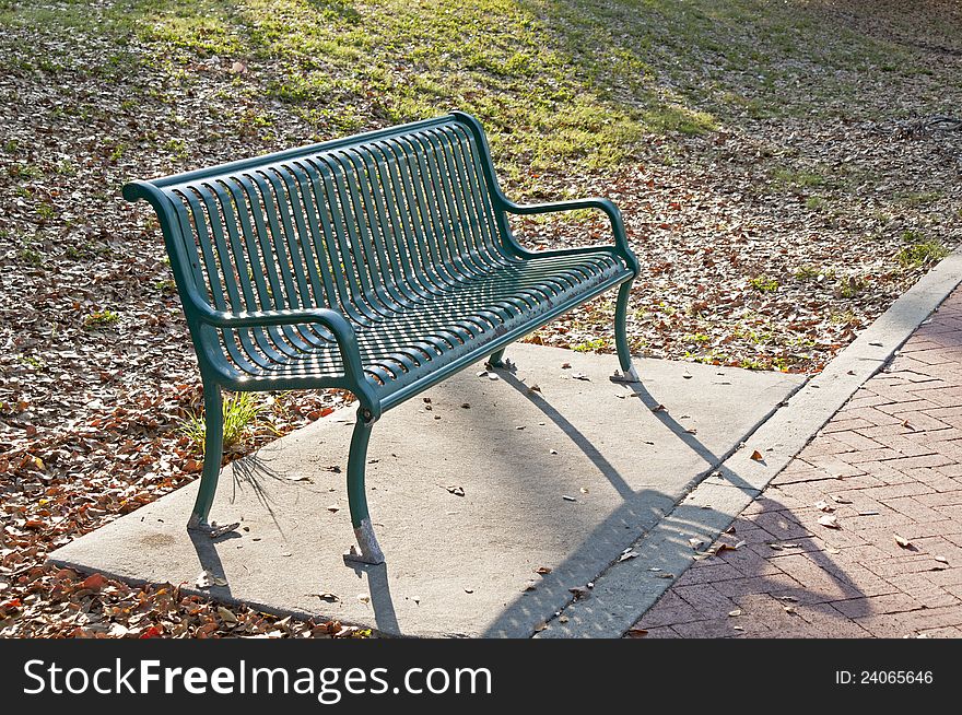 Green metal bench at a harbor on a sunny day