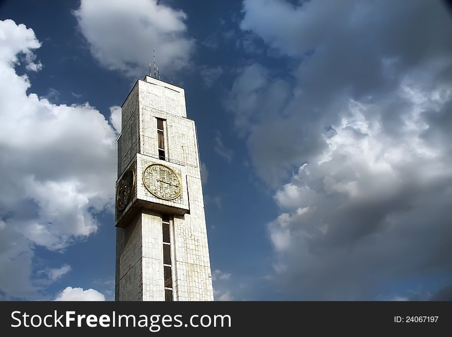 Tower with hours. Against cloudy sky