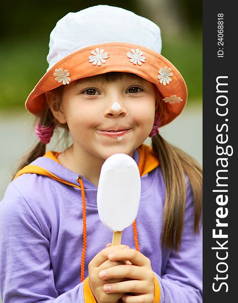 Portrait of a cheerful girl with ice cream that looks into the camera. Portrait of a cheerful girl with ice cream that looks into the camera