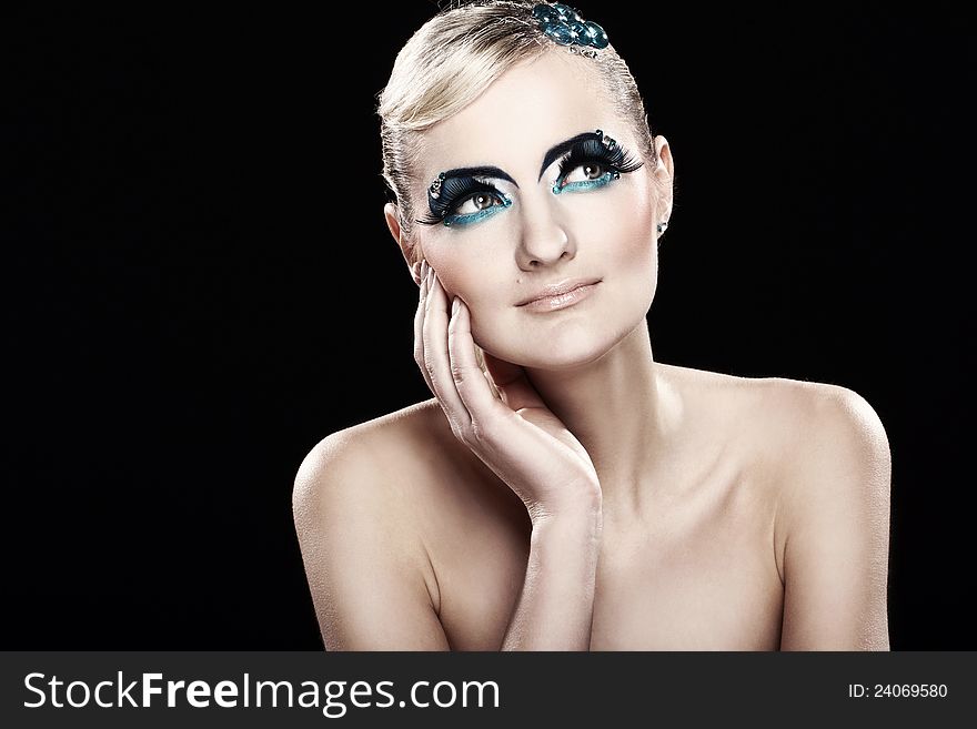 Beautiful blonde with artistic makeup over black background