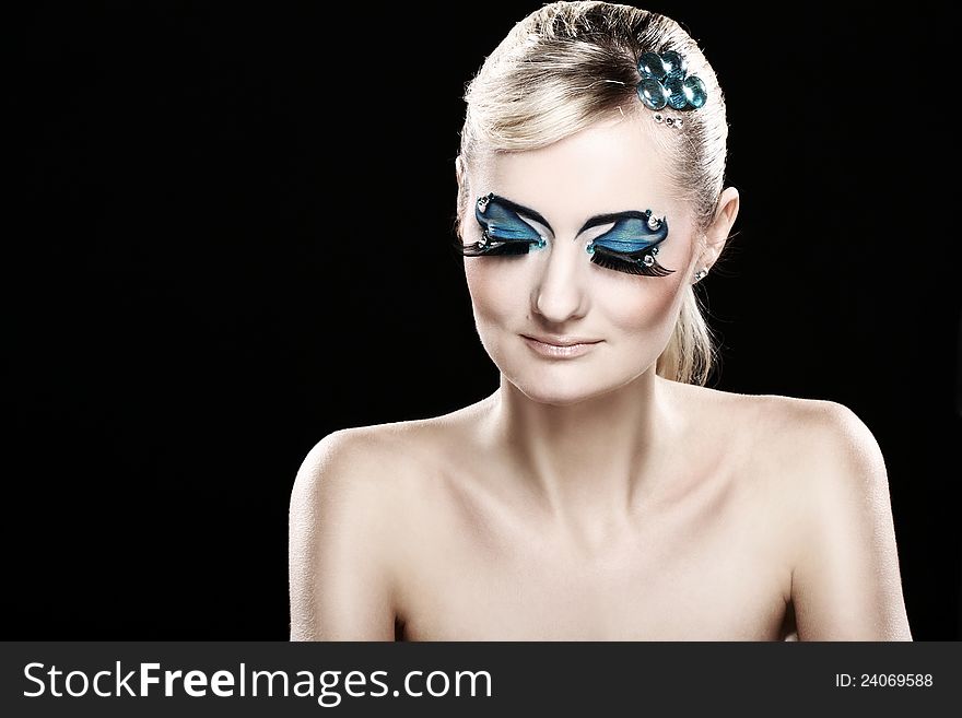 Beautiful blonde with artistic makeup over black background