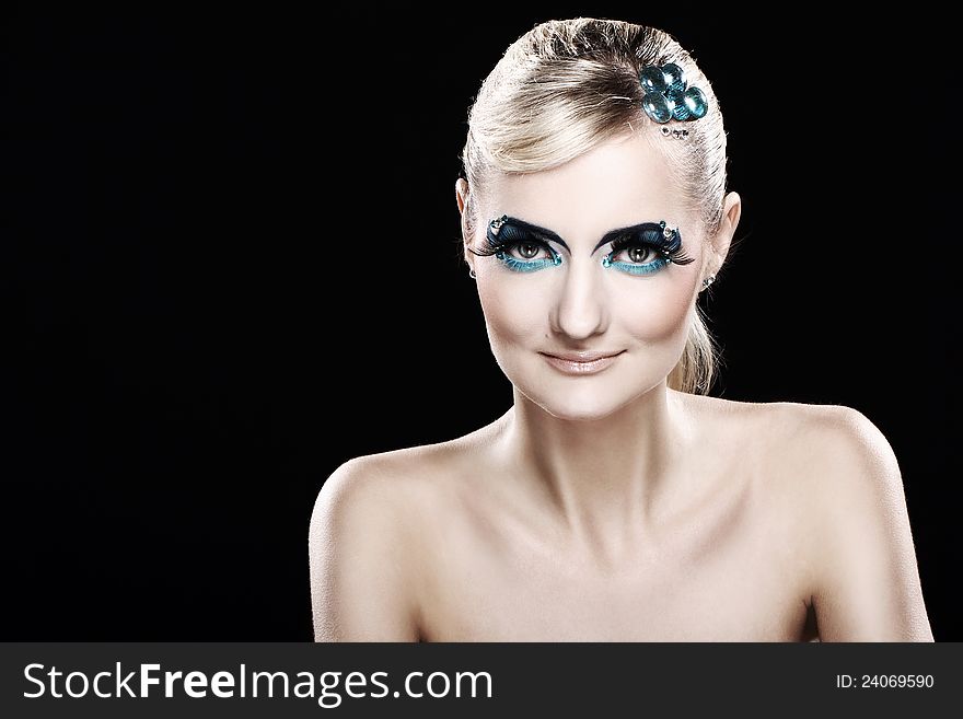 Beautiful blonde with artistic makeup over black background