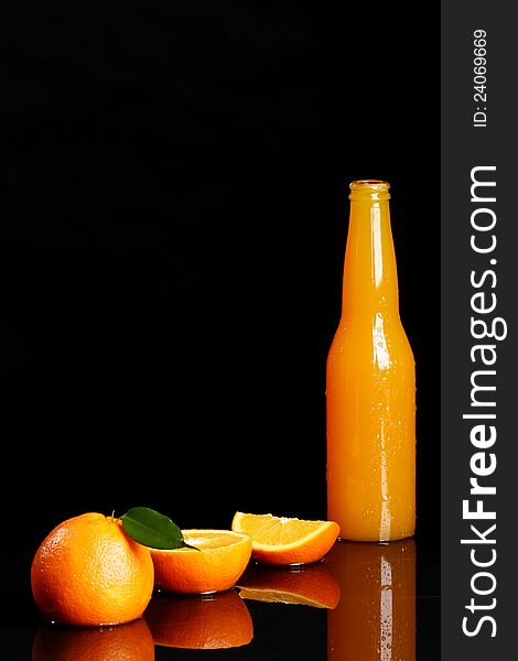 Fresh orange drink over black background
