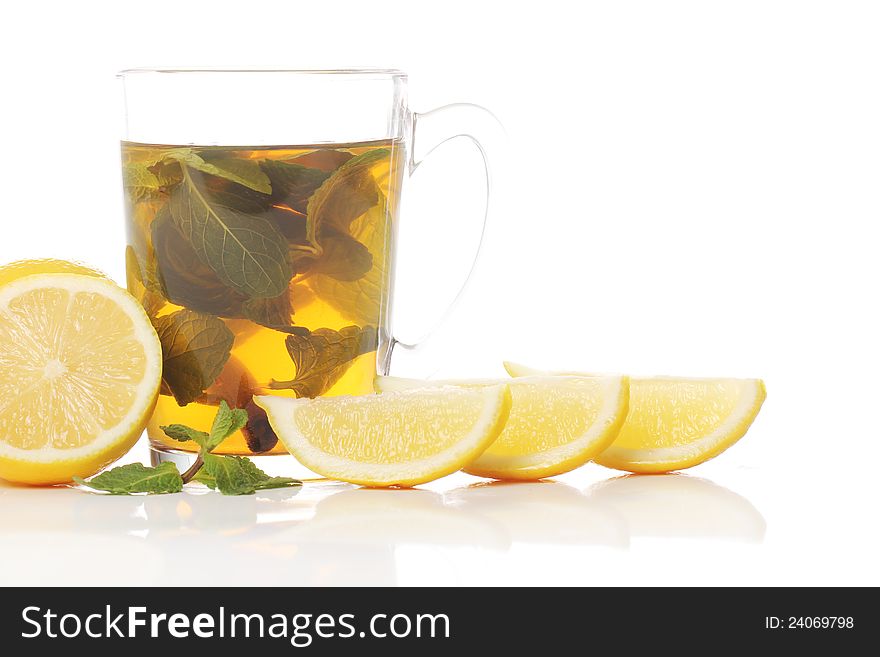 Mint tea and fresh lemons over white background