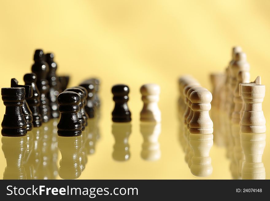 Chessman set in a row on yellow background with reflection. Chessman set in a row on yellow background with reflection