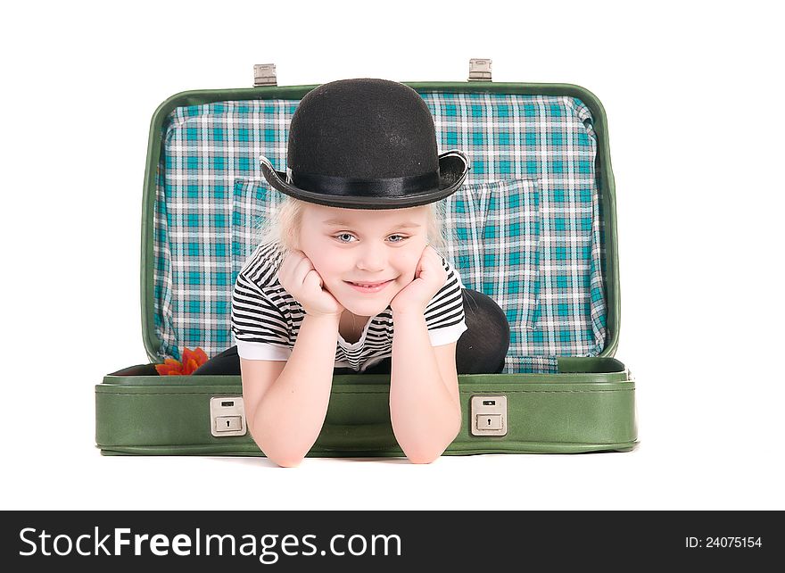 Child sitting in an old green suitcase in anticipation of traveling on a white background