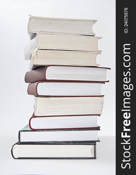 Stack of books with opened notebook on white