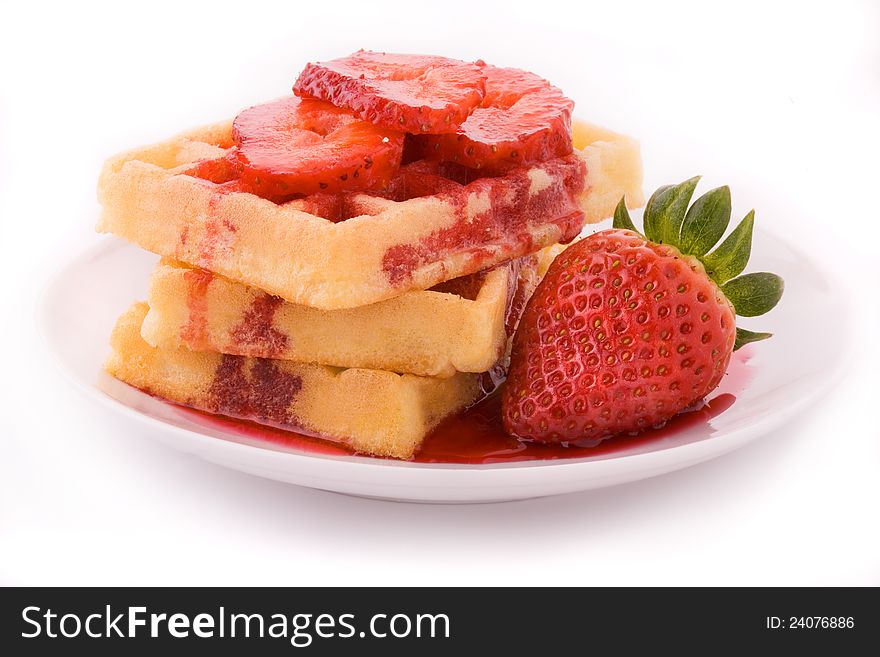 The group of waffles with strawberries on the plate situated on the white background. The group of waffles with strawberries on the plate situated on the white background