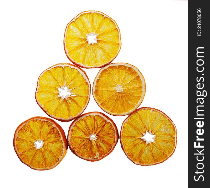 Slices of dried oranges in a triangle arrangement, isolated on white background