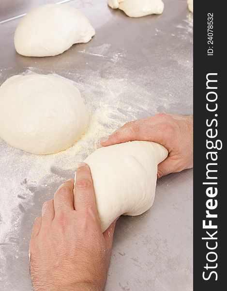 Baker kneads the flour on a shelf, to make bread. Baker kneads the flour on a shelf, to make bread