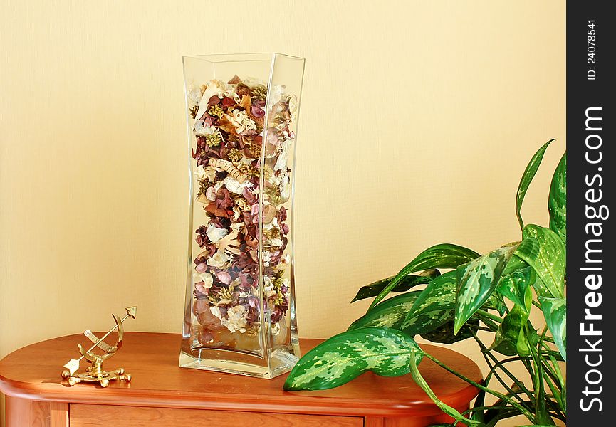 Clear vase on a brown wooden pedestal. Clear vase on a brown wooden pedestal