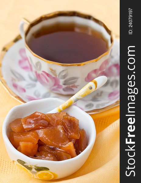 From quince jam and a cup of tea on a yellow background. From quince jam and a cup of tea on a yellow background