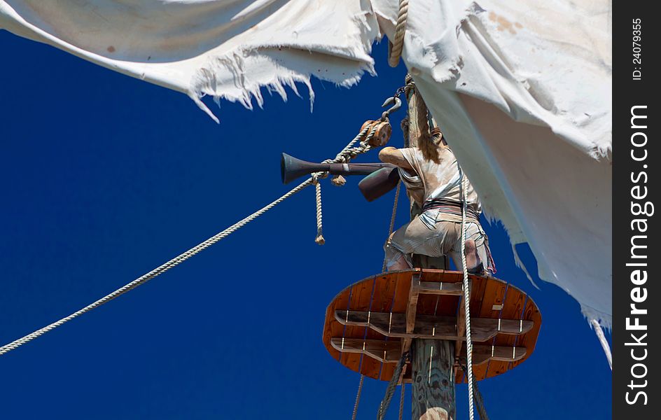 Observing pirate scout on the lookout in nest on ship's mast