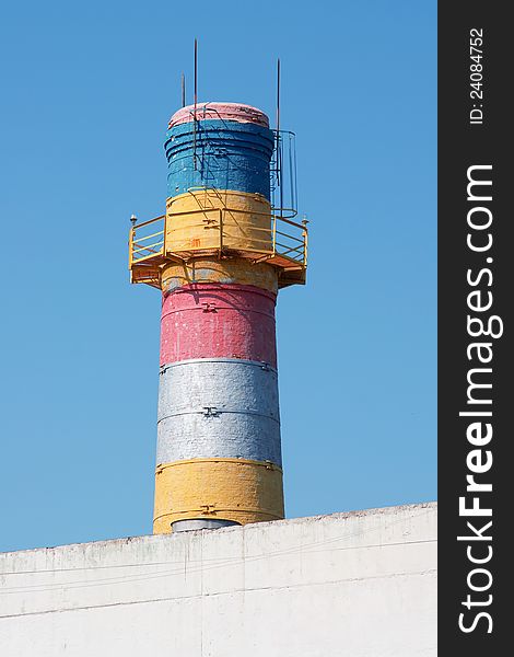 Painted brick chimney with a ladder against the blue sky. Painted brick chimney with a ladder against the blue sky