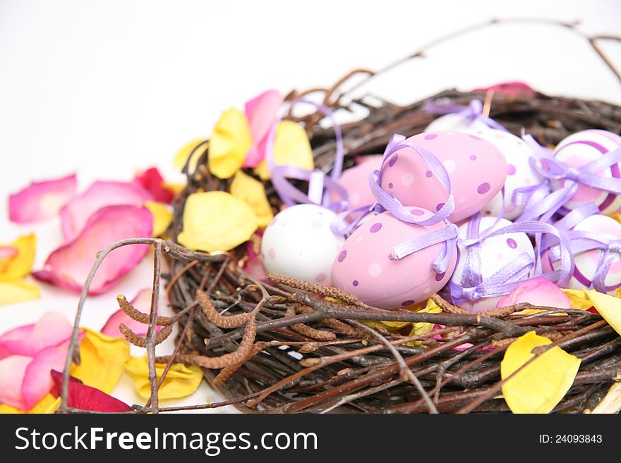 Multicolored Easter eggs in a nest and wicker basket