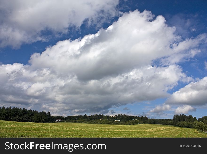 Clouds on a windy day above the field and forest. Clouds on a windy day above the field and forest