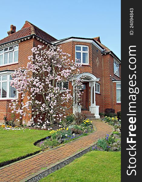 Photo of a beautiful kent country cottage house with immaculate landscaped garden with a lovely magnolia tree in full bloom. Photo of a beautiful kent country cottage house with immaculate landscaped garden with a lovely magnolia tree in full bloom.