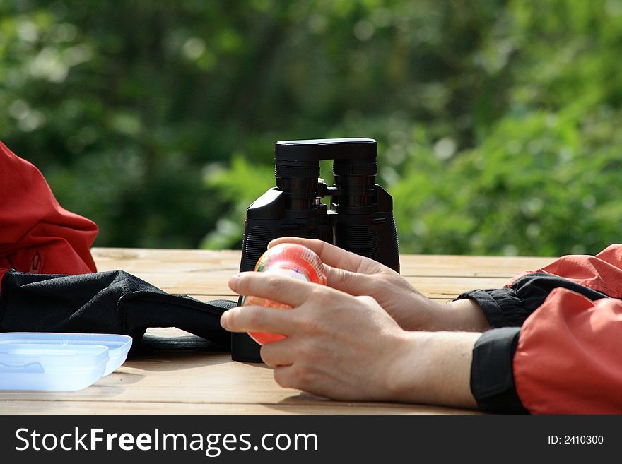 The hands of a tourist with a black binoculars. The hands of a tourist with a black binoculars