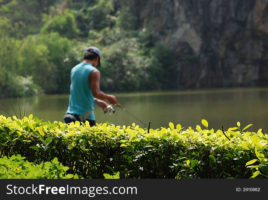 Teen fishing in the pond at the parks