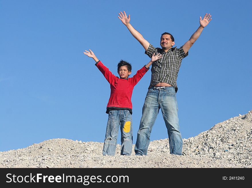 Father and his son standing on the hill and enjoying the day