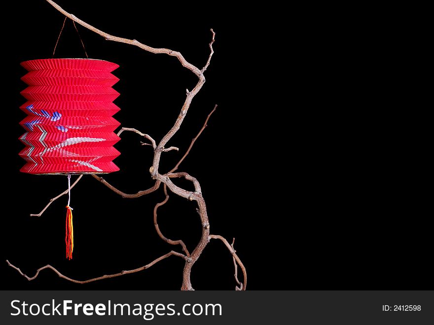 Single red Chinese paper lantern on a tree branch against a black background - for Chinese New Year of the Rat. Single red Chinese paper lantern on a tree branch against a black background - for Chinese New Year of the Rat