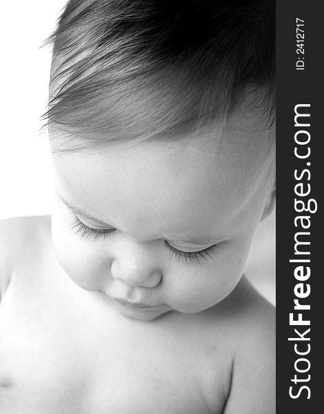 Black and white image of a beautiful baby looking down so his eyelashes are visible. Black and white image of a beautiful baby looking down so his eyelashes are visible