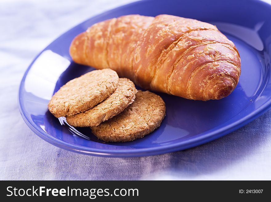 Butter croissant and biscuits in a blue dishware