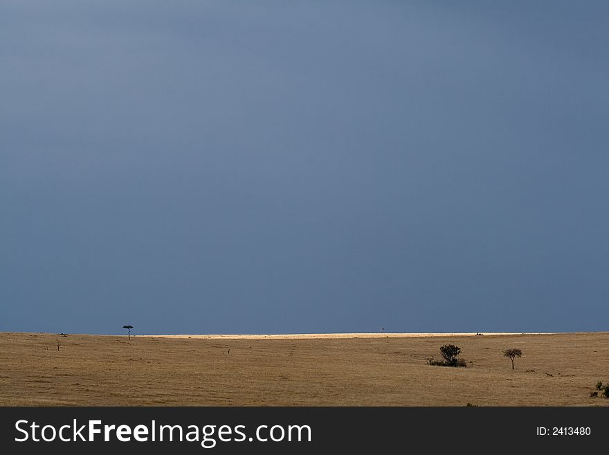 Rainclouds and sunshine over serengeti plains, masai mara, kenya