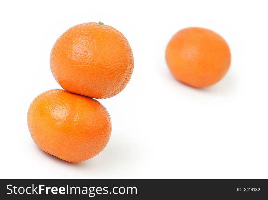 Three Mandarins / Tangerines isolated over white background. Focus on two at left side.