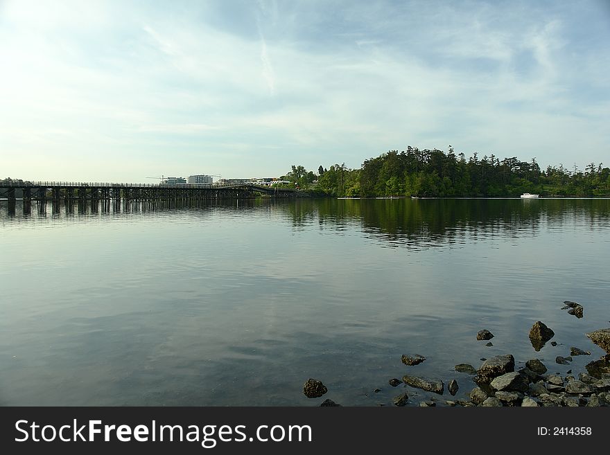 Pedestrian bridge over the gorge inlet in Victoria, BC.  Rowing club practising on the calm water