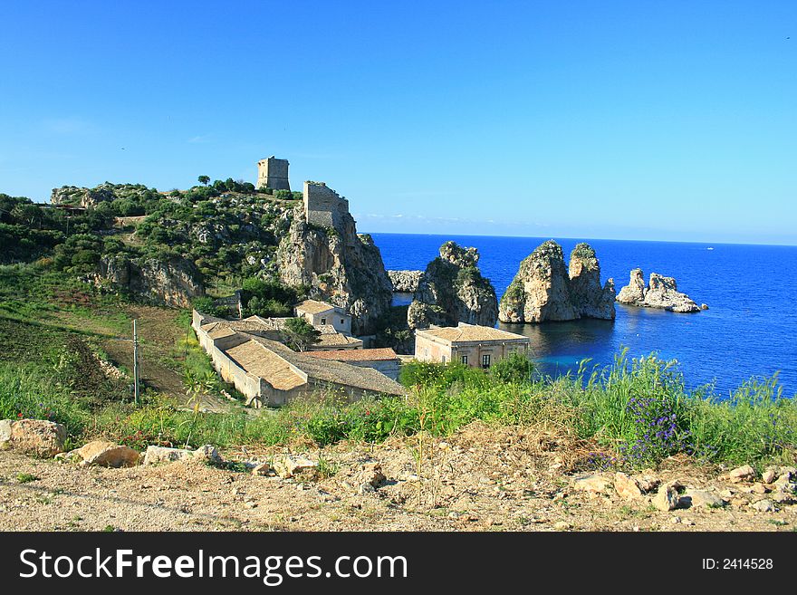 Blue Mediterranean Landscape. Coast, Rocks and sea.Wien on the ancient tuna fishing costruction and bay. Sicily Summer Italy. Blue Mediterranean Landscape. Coast, Rocks and sea.Wien on the ancient tuna fishing costruction and bay. Sicily Summer Italy