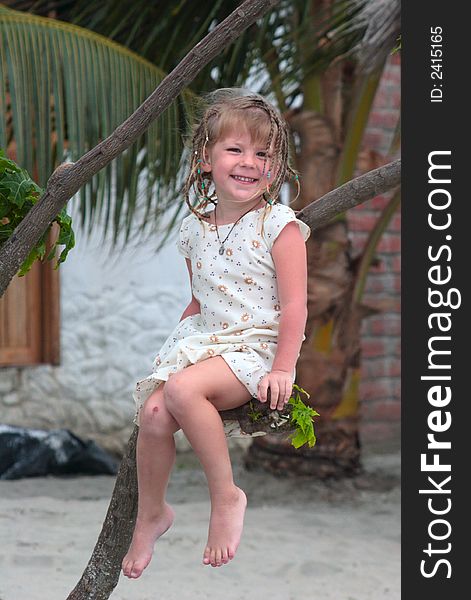 Happy little girl sitting on the tree. Happy little girl sitting on the tree