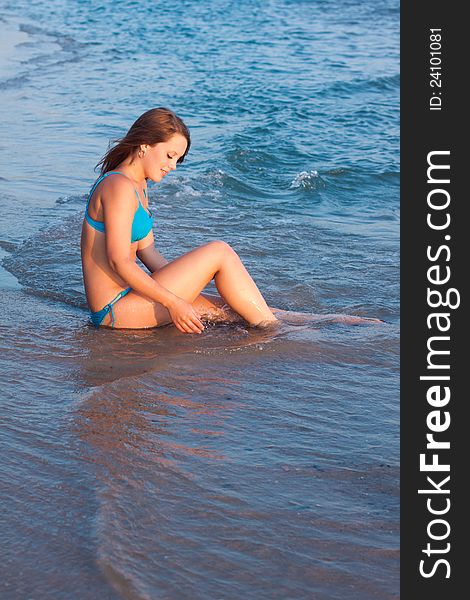 Young girl in a blue bikini looking sideways on the sea. Young girl in a blue bikini looking sideways on the sea