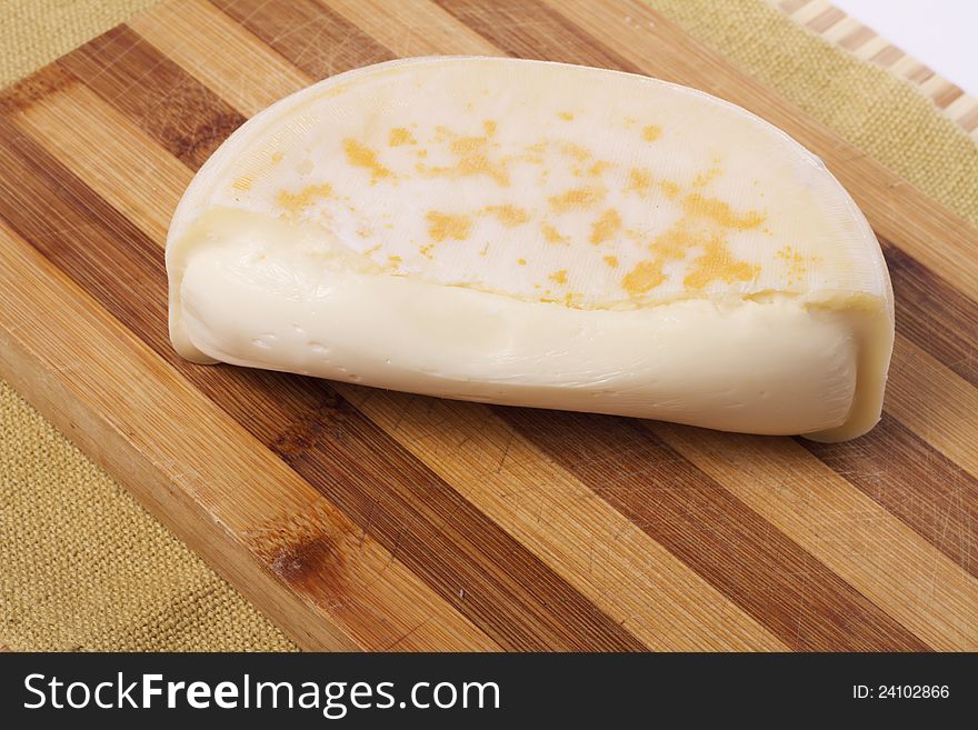 Close view of a piece of soft cheese on a table.